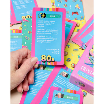 A box titled '80s Trivia Cards' with illustrations of 80s inspired roller skates, cassette tape and a Rubik's cube.