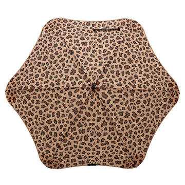 An open umbrella printed with leopard print resting on its black handle.