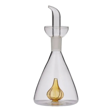 A clear glass oil pourer with an amber glass garlic bulb in the bottom.