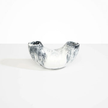 A resin vase in a shallow U shape in white marble.