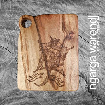 Wooden cutting board with engraved design of a possum on a textured gray background, featuring the brand 'ngarga warden'.