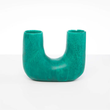 A U shaped resin vase in teal green.
