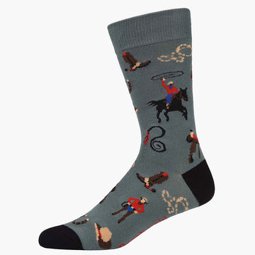 A dark grey sock with a black heel and toe and illustrated with cowboys.