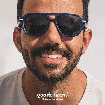 Blue sunglasses with dark lenses on a white background, featuring a Good Design Award logo.