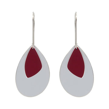 A pair of drop earrings in stainless steel with a large silver tear drop shape and a smaller red shape over the top.