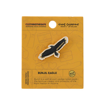Shoe charm packaging with an eagle design on a yellow background.