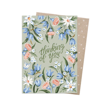 A greeting card with the text 'Thinking of you' in the middle surrounded by bluebell flowers.