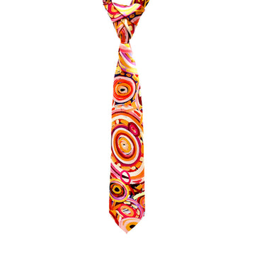 A tie is hanging and printed with artwork by Cedric Varcoe in shades of orange.