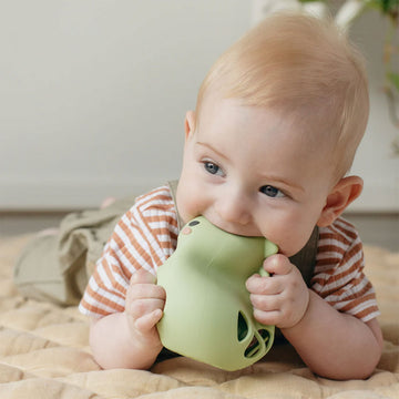 A silicone rattler shaped like a dinosaur with cut out tear drops on the bottom.