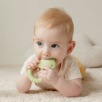 A silicone teething ring shaped like a green dinosaur.