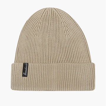 A knitted beanie in latte laying flat with a 'bamboozled' label attached.