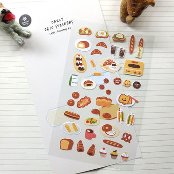 A sticker sheet with small stickers of food including bread, cookies and cupcakes.
