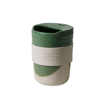 A ceramic travel mug with a green speckle pattern.