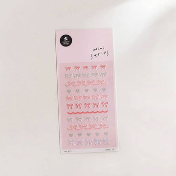 A sticker sheet with small stickers of pink and silver bows.