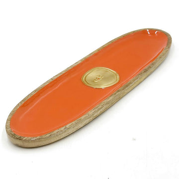 Orange wooden object with a gold emblem on a white background.