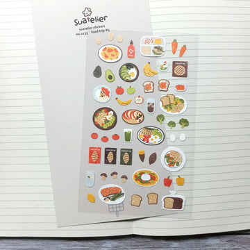 A sticker sheet with small stickers of different foods including fruits, vegetables and meat dishes.