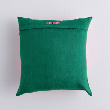 Front view of an pink cushion embroidered with green and red flower and leaf motifs.