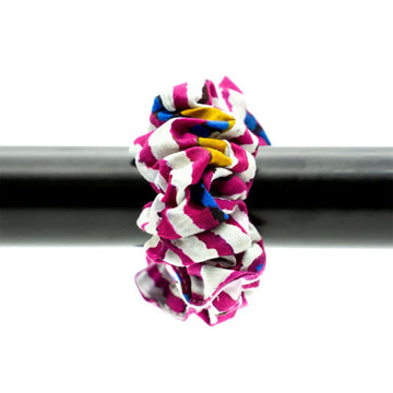A scrunchie printed with a pink and white stripe design is attached to a black pole.