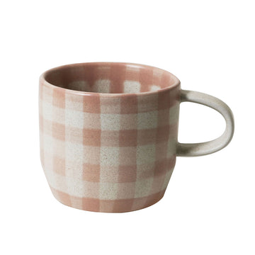 A ceramic mug printed with a pink checkered pattern.
