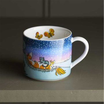 A child's mug with an illustration of a cat sitting on a pony.