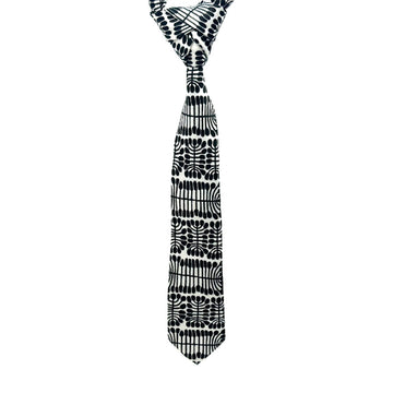 A tie is hanging and printed with artwork by Mitjili Napurrula in black and white.