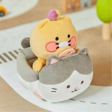 A bear shaped plush toy sitting in a cat shaped plush car.