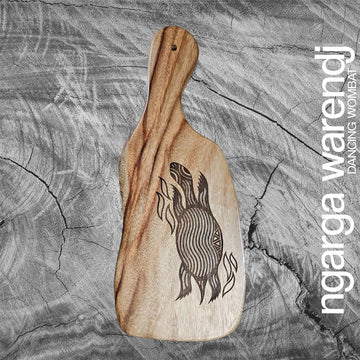 A wooden board with a long handle on one end and an etch drawing of a long neck turtle.