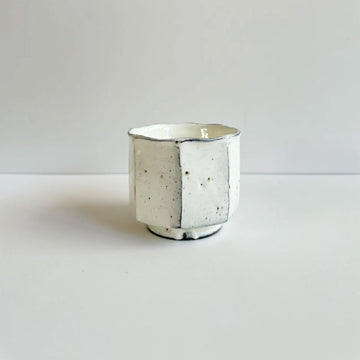 A ceramic cup with a hexagon shaped design.