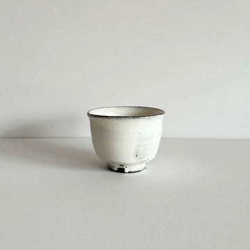 A ceramic tea cup made from white stoneware.