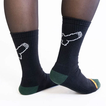 Close up of a person wearing black socks printed with a white outline of an eagle.