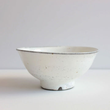 A ceramic stoneware bowl in white with black speckles.