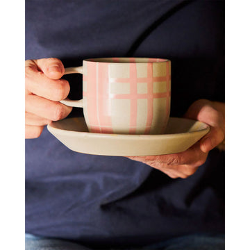 Mug with pink and gray checkered pattern on a white background.