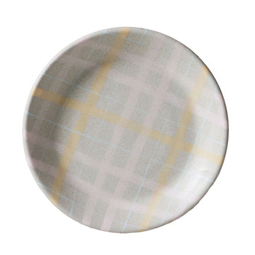 Round ceramic plate with plaid pattern on a white background.