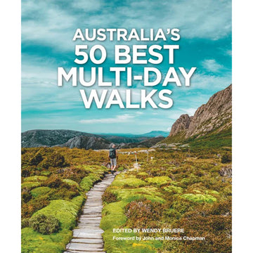 'Australia's 50 Best Multi-Day Walks' book cover featuring a photo of a person walking along a wooden path with plants and mountains in the background.