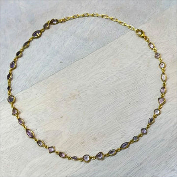 A gold necklace with amethyst stones.