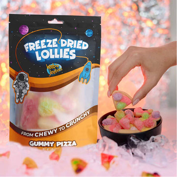 Packaging of freeze-dried lollies with gummy pizza design on an orange background.