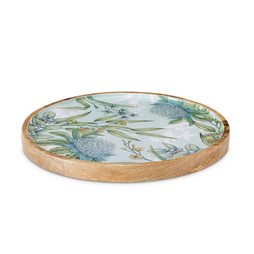 A round wooden platter printed with illustrated flowers in blue on the top.