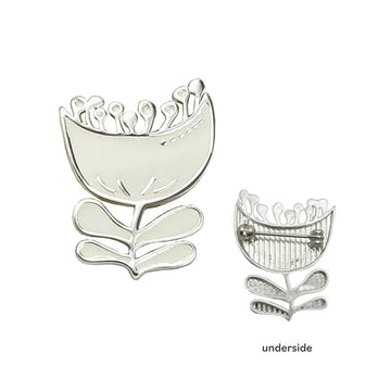 A silver brooch in the shape of a tulip and a second brooch showing the pin on the underside.