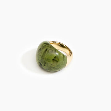 A brass ring with a large resin design on the front in olive green.