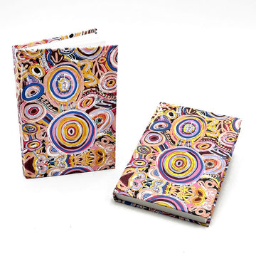 Two hardcover notebooks pictured printed with colourful Indigenous artwork.