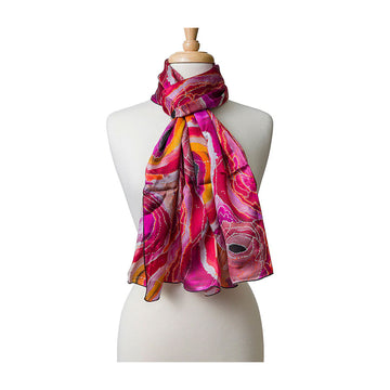 A silk scarf in pink printed with artwork around the neck of a mannequin. 