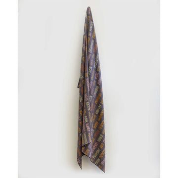 A blanket hanging off a hook printed with a geometic design.