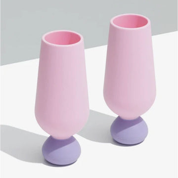 Two pink and purple silicone champagne glasses on a light gray background.