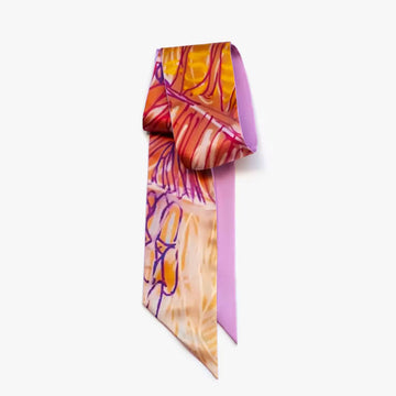 A silk twilly scarf printed with artwork by Sonia Kurarra in red, orange and purple.