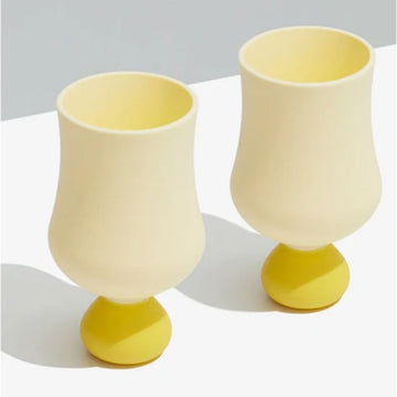 Two yellow silicone goblet cups on a light gray background