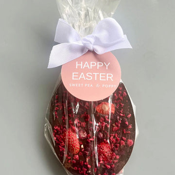 Chocolate with red berries and a 'Happy Easter' tag on a grey background.