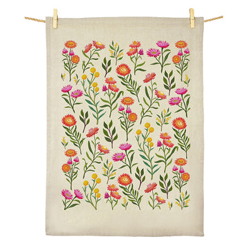 A cotton tea towel printed with wildflowers hanging off a rope.