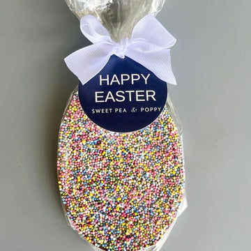 An egg shaped chocolate covered with sprinkles in clear packaging.