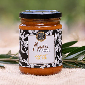 Jar of Morella Grove Gourmet Peri Peri on a natural background with olive leaves.