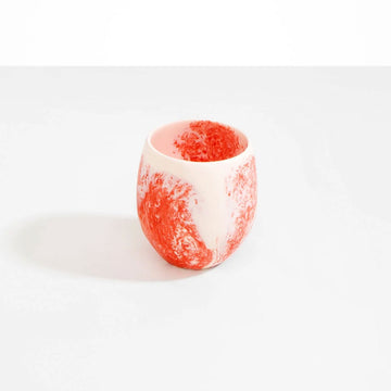 A cup made from orange pink resin.